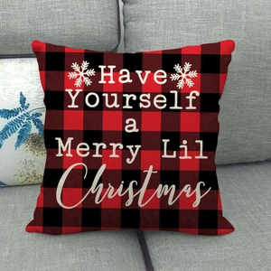 Detail of red and black buffalo plaid Christmas pillow cover with white festive lettering