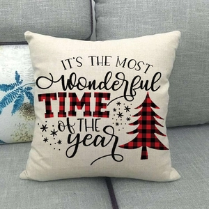 Detail view of linen Christmas pillow case with red plaid lettering on grey sofa