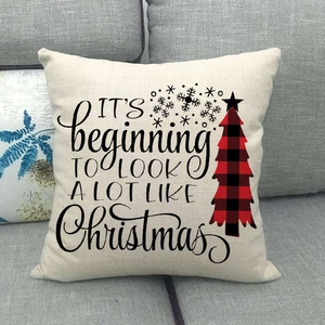 British plaid Christmas tree linen pillowcase with festive typography on gray sofa