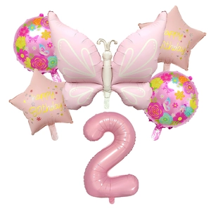 Macro detail of matte pink butterfly balloon set with star and floral birthday decorations