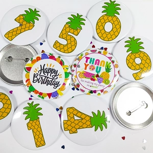 Details van blikken badges met ananasmotieven en veiligheidsspelden voor verjaardag