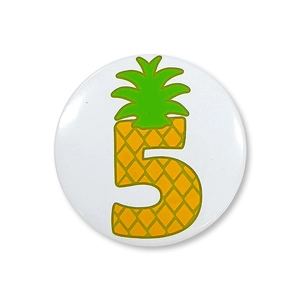 Detail van ronde ananas nummer 5 badge met tropisch fruit thema en levendige gele textuur