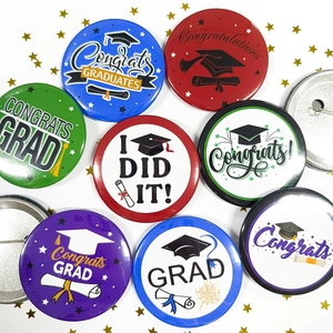 Detail of Graduation tinplate badges with graduation caps and Congrats Grad text