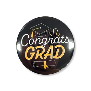 Detail of Congrats GRAD tinplate badge with graduation cap and diploma graphic