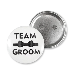 Dettaglio della spilla Team Groom con icona papillon e retro con spilla di sicurezza