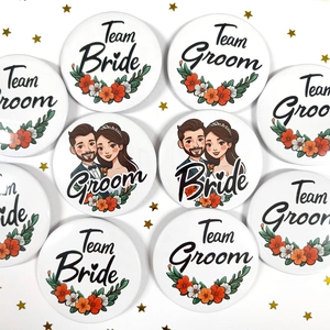 Close-up of Team Bride and Groom tinplate badges with floral patterns for wedding party decor