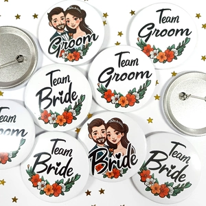 Detailed view of Team Bride and Groom tinplate badges with floral patterns for weddings