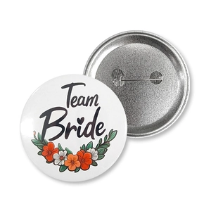 Detail of Team Bride tinplate badge showing the floral design and safety pin back