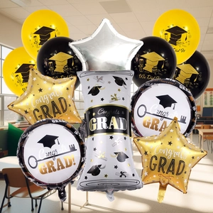 Close-up of black and gold graduation balloons with diploma scroll and star shapes