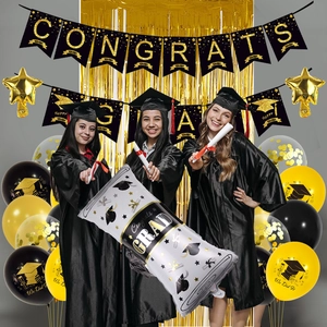 Detail of graduation party kit with Congrats banner gold fringe and mortarboard balloons