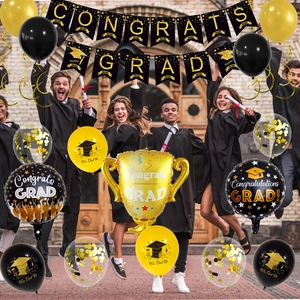 Detail of black and gold graduation party set with Congrats Grad banner and trophy balloon