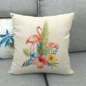 Detail of linen cushion cover featuring watercolor tropical flamingos and palm leaves