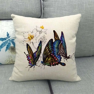 Detail of colorful butterfly and floral print on natural linen textured throw pillow cover