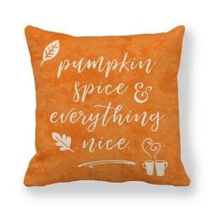Detail of orange linen pillowcase with 'pumpkin spice' text and autumn leaf graphics