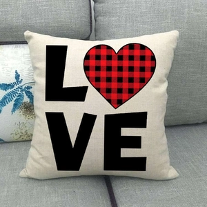 Gros plan sur la housse de coussin en lin avec texte LOVE et motif cœur à carreaux