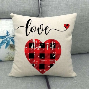 Détail de la housse de coussin en lin avec cœur à carreaux rouges et texte love cursive