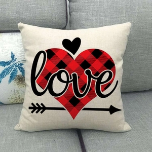 Détail d'une housse de coussin en lin avec cœur à carreaux, flèche et texte Love