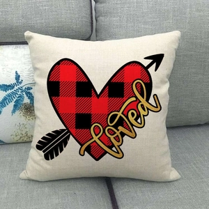 Détail d'un coussin de Saint-Valentin en lin avec cœur à carreaux et texte Loved