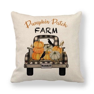 Detail of linen pillow cover featuring a black checkered pumpkin truck and farm text