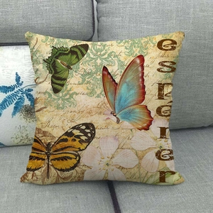 Housse de coussin en lin avec timbres papillons vintage sur un canapé en tissu gris