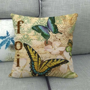 Taie d'oreiller vintage en lin avec motifs papillons et fleurs sur un canapé gris