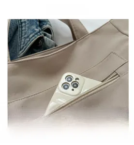Detail of canvas tote bag featuring an external zipper pocket and smartphone storage space