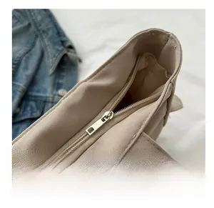 Detail view of the smooth silver zipper closure and durable canvas fabric on the tote bag