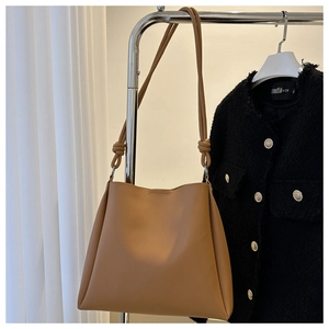 Close-up of brown matte tote bag with knotted shoulder strap and textured finish