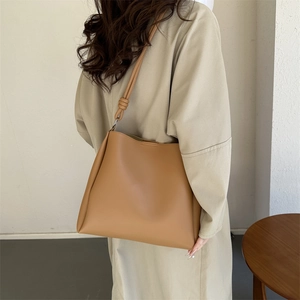 Minimalist brown faux leather tote bag with stylish knotted shoulder strap detail