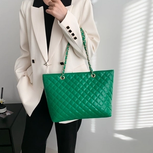 Quilted green chain tote bag with rhombus pattern shown on model in stylish lighting