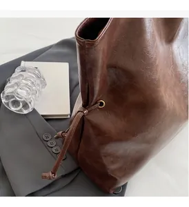 Détails macro d'un cabas en cuir marron foncé avec cordon de serrage et œillets dorés