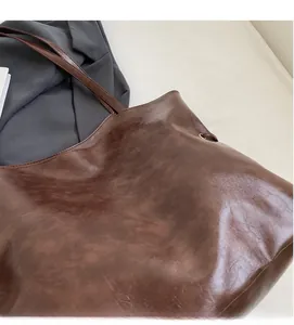 Gros plan d'un cabas marron montrant la texture du cuir ciré et un style rétro chic