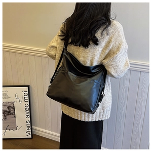 Détail d'un grand sac fourre-tout noir en cuir PU porté en bandoulière pour femme