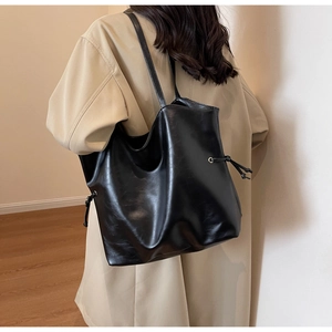 Grand sac cabas vintage en cuir noir pour femme, porté à l'épaule de manière élégante
