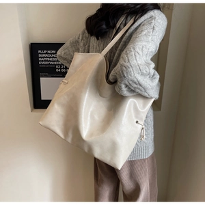 Détail du grand sac cabas crème en cuir PU avec cordon latéral et texture souple et élégante