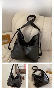 Détail du sac hobo en cuir PU noir avec bandoulière réglable et poche latérale