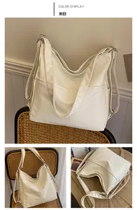 Détail d'un grand cabas beige en cuir PU avec poche frontale et boucle argentée métallique