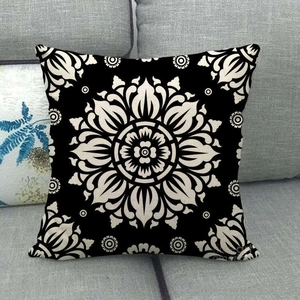 Detail of linen cushion cover with beige mandala pattern on black fabric