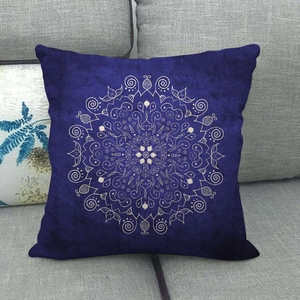 Détail d'une housse de coussin carrée en lin bleu marine avec motif mandala blanc