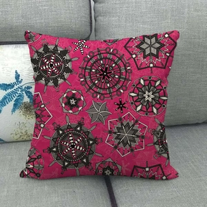 Détail d'un coussin en lin rose avec motif mandala géométrique sur un canapé gris