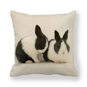 Detailed close-up of linen fabric texture featuring two realistic black and white rabbits
