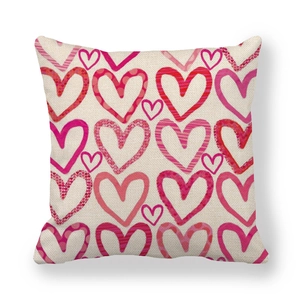 Macro shot of linen throw pillow cover with hand-drawn red and pink heart patterns