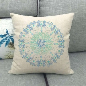 Macro view of linen cushion cover showing nautical mandala with blue crab and seahorse