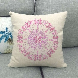 Close-up of coral and crab pattern on beige linen pillowcase resting on a sofa