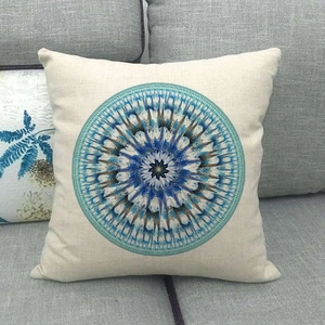 Blue mandala geometric pattern on linen throw pillow cover placed on a sofa