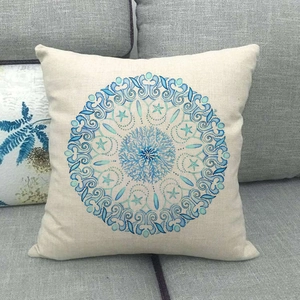 Close-up of linen pillow cover featuring a blue nautical mandala with starfish and shells