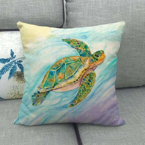 Detailed view of turtle watercolor print on square linen throw pillow cover on a grey sofa