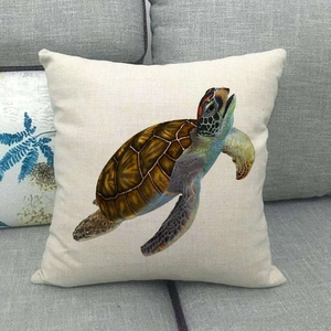 Detailed view of sea turtle print on off-white linen texture pillowcase on grey sofa