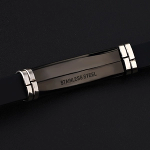 Macro detail van een heren siliconen armband met gegraveerde roestvrijstalen plaat
