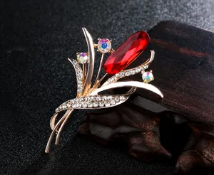 Macro shot of handcrafted orchid brooch with red teardrop crystal and rose gold plating